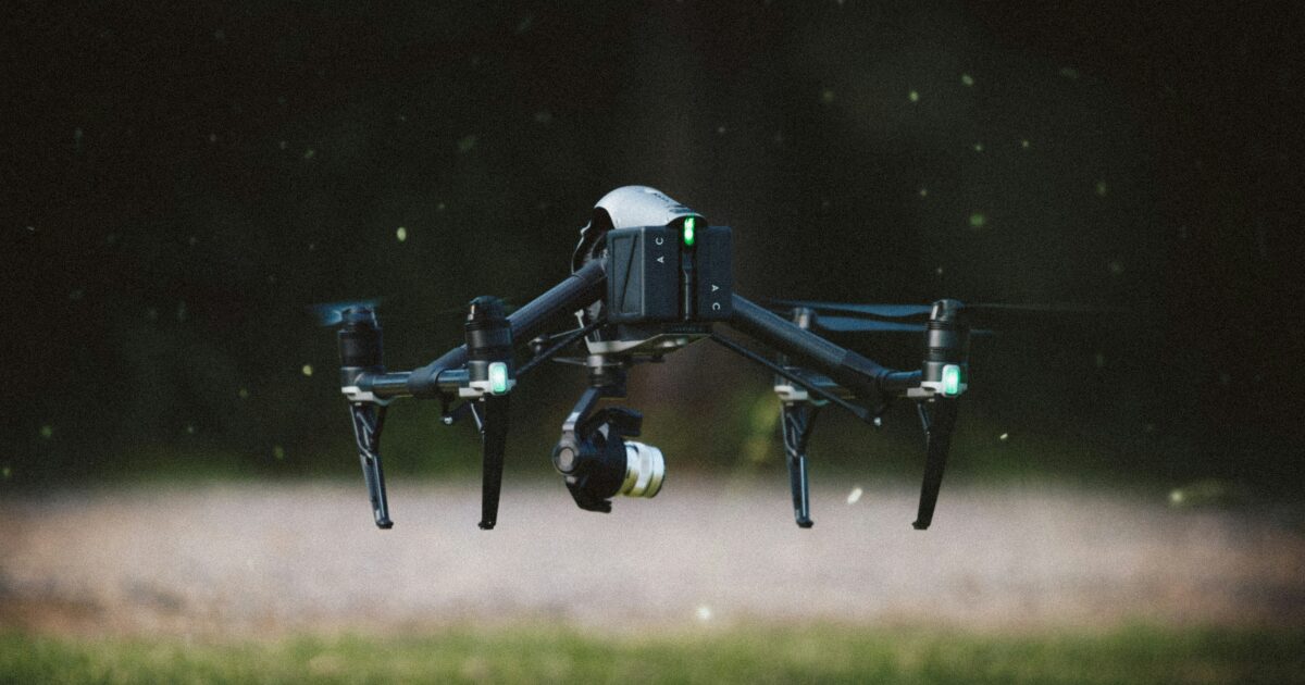 草地上をホバリングするプロフェッショナルドローン