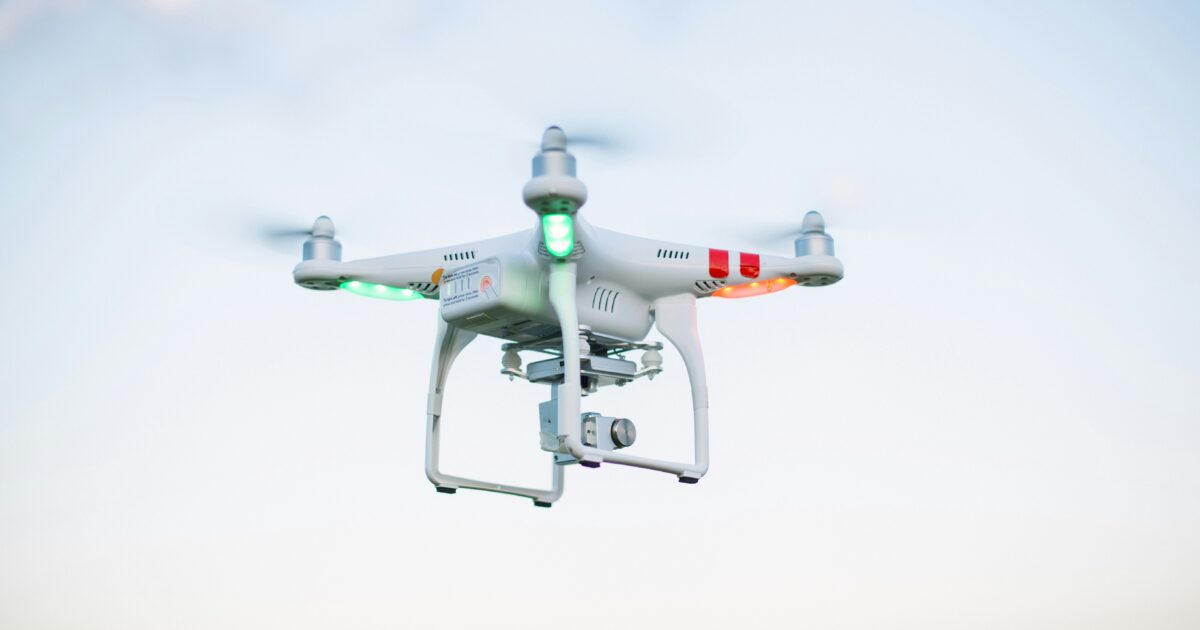 白い空を背景に飛行するLEDライト付きドローン