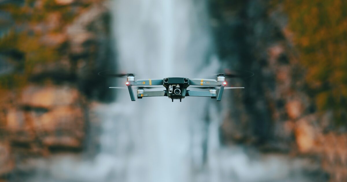 滝を背景にホバリングするMavic Proドローン