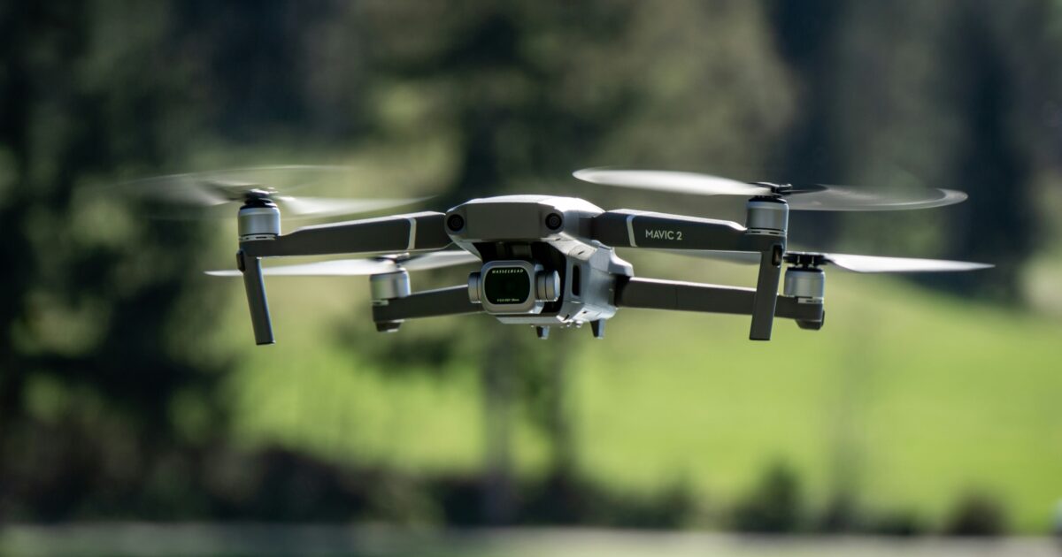 森林を背景にホバリングするMavic 2ドローン