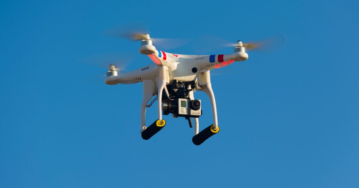 青空を飛行するGoPro搭載の白いドローン